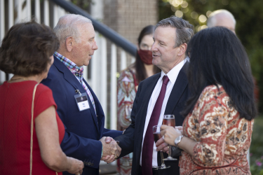 President McCullough shaking hands with a guest while chatting