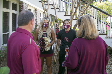 Two FSU cheerleaders chatting with guests