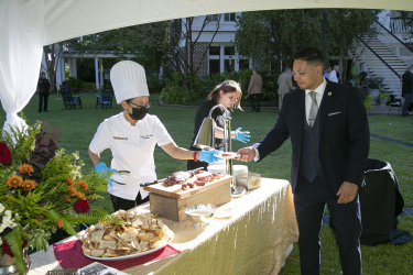 A male guest picking up a plate of hor d'oeuvres
