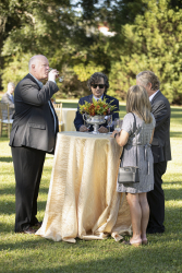 Four guests standing and talking at a table outdoors