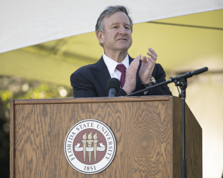 President McCullough clapping at the podium