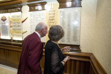 A couple looks for thier name in the Garnet Society section of the new donor wall